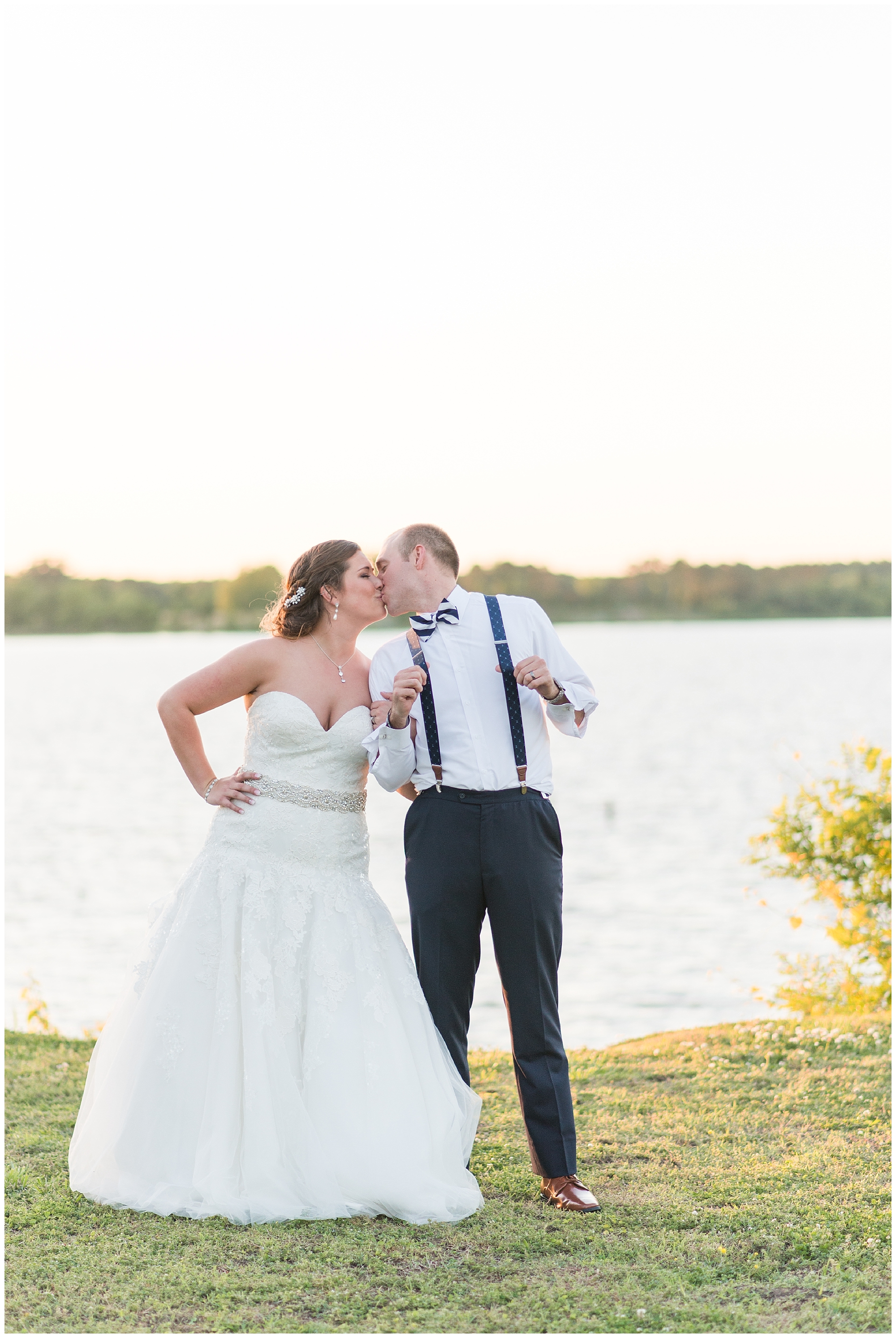 bride and groom kissing by water
