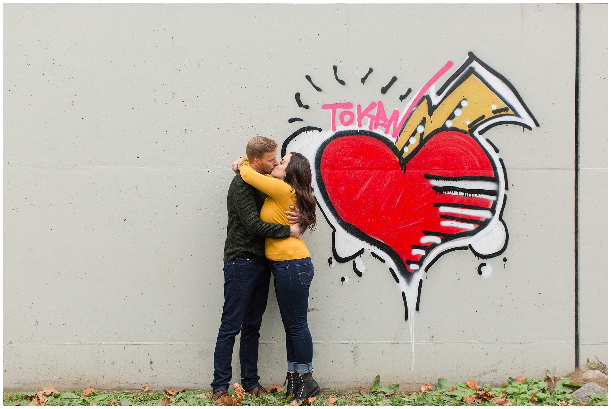 couple posing infant of graffiti wall Richmond Virginia